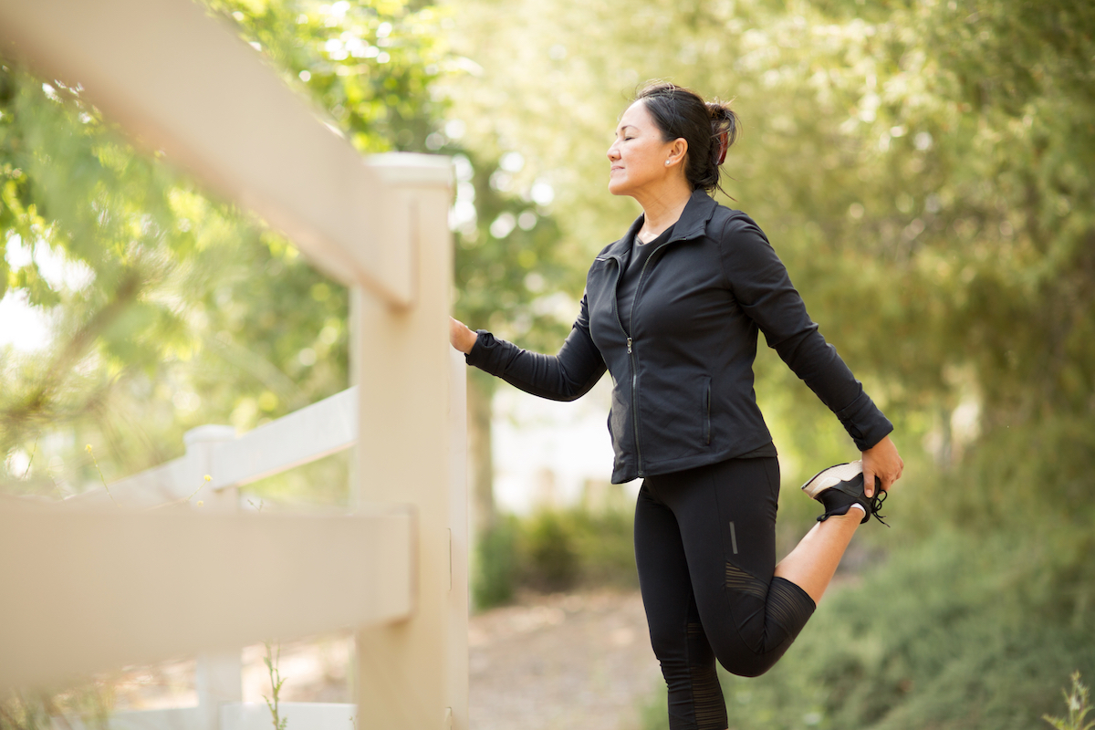 Asian woman stretching before a run