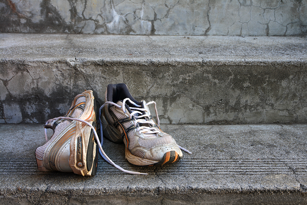 A pair of old running shoes on stairs