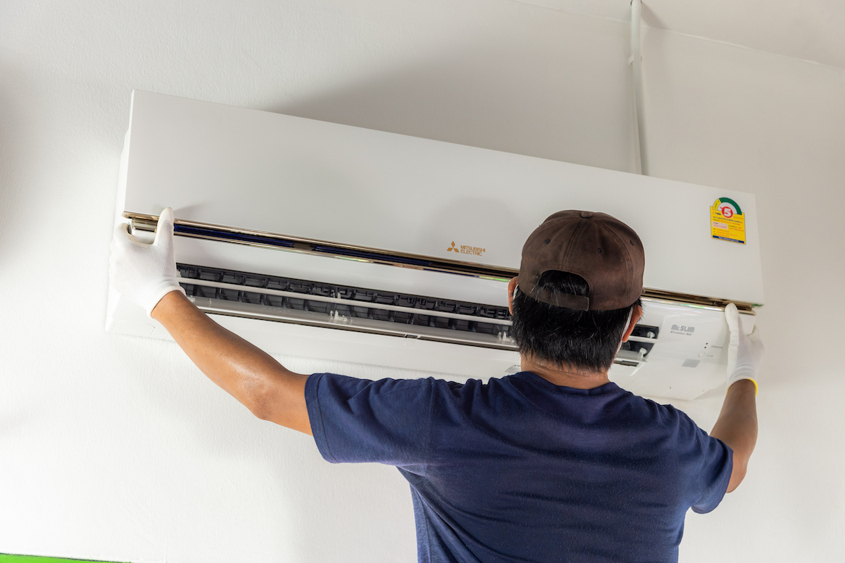 Man installing a Mitsubishi Electric air conditioner