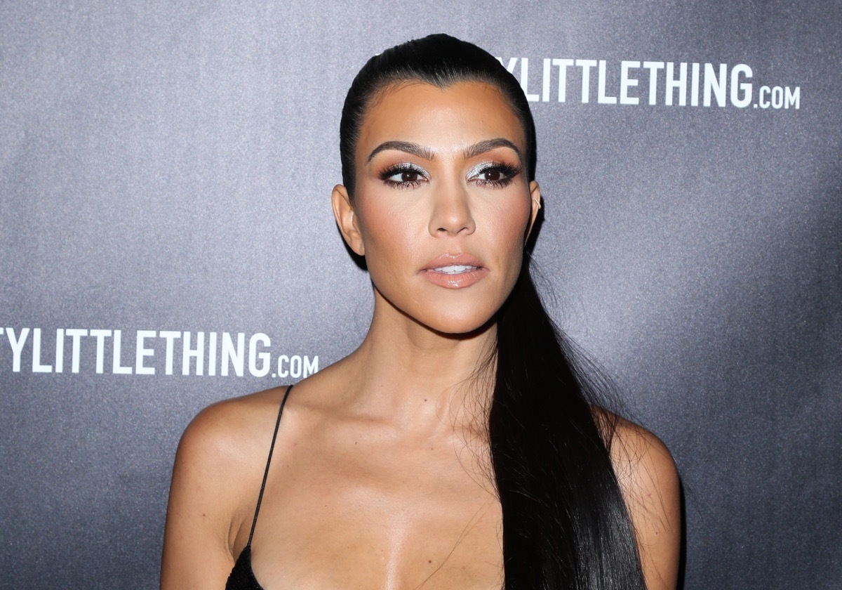 kourtney kardashian on red carpet in black strappy dress