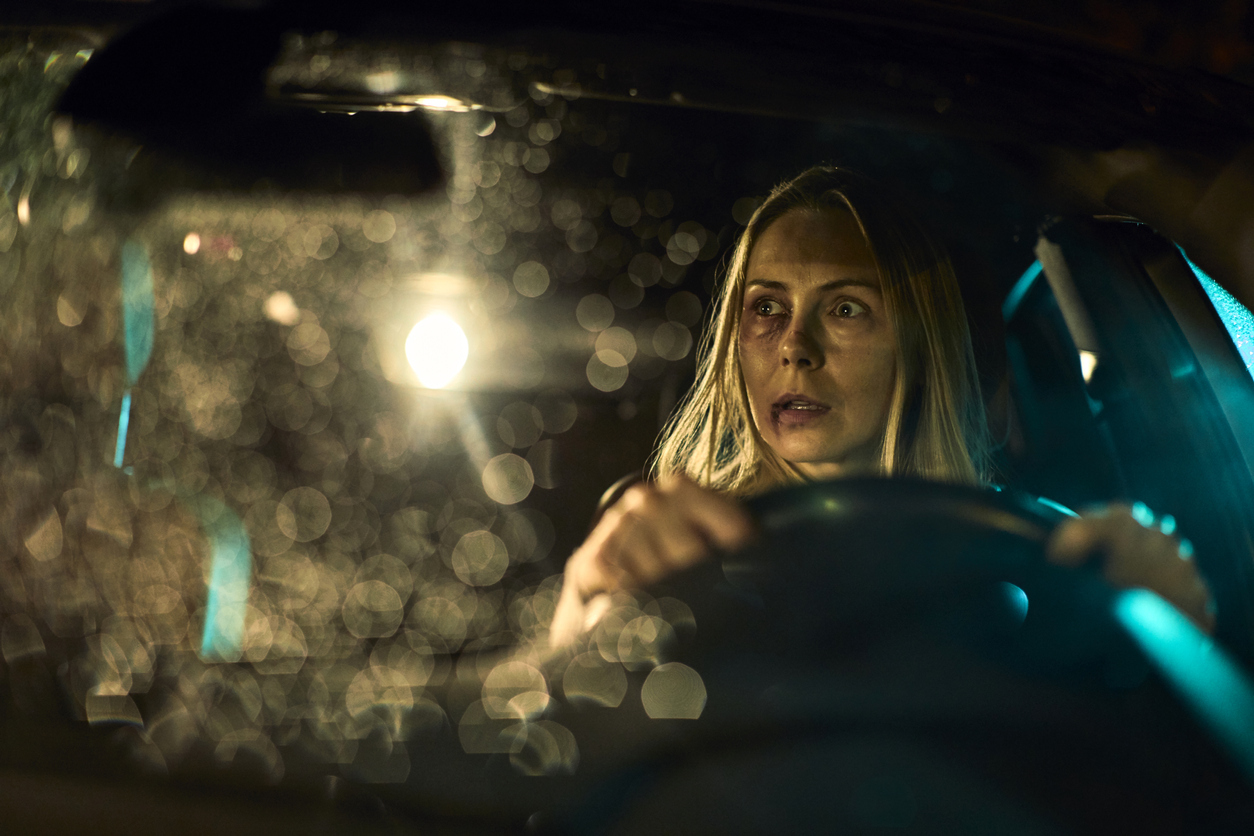 Close up of a injured and scared woman driving a car