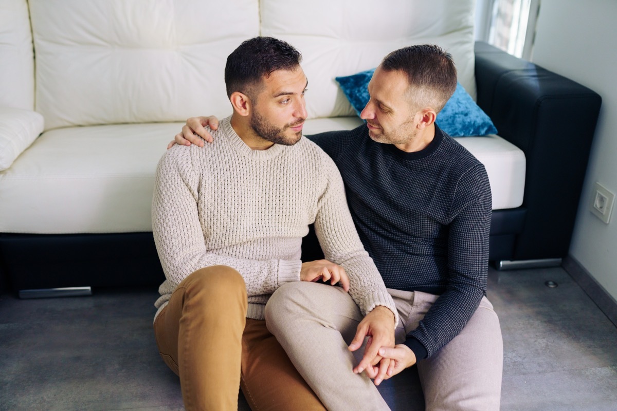 couple sitting near the couch at home in a romantic moment. 