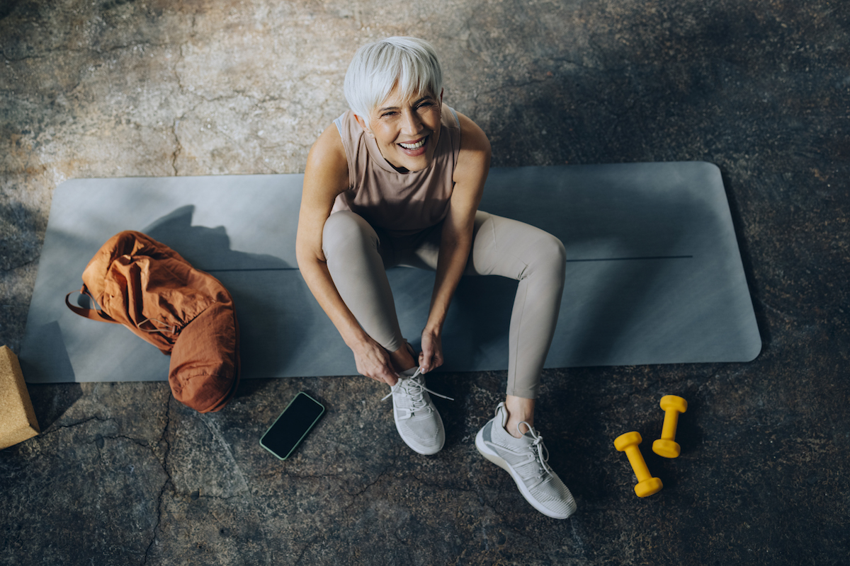 Athletic older woman with short hair in workout wear with weights