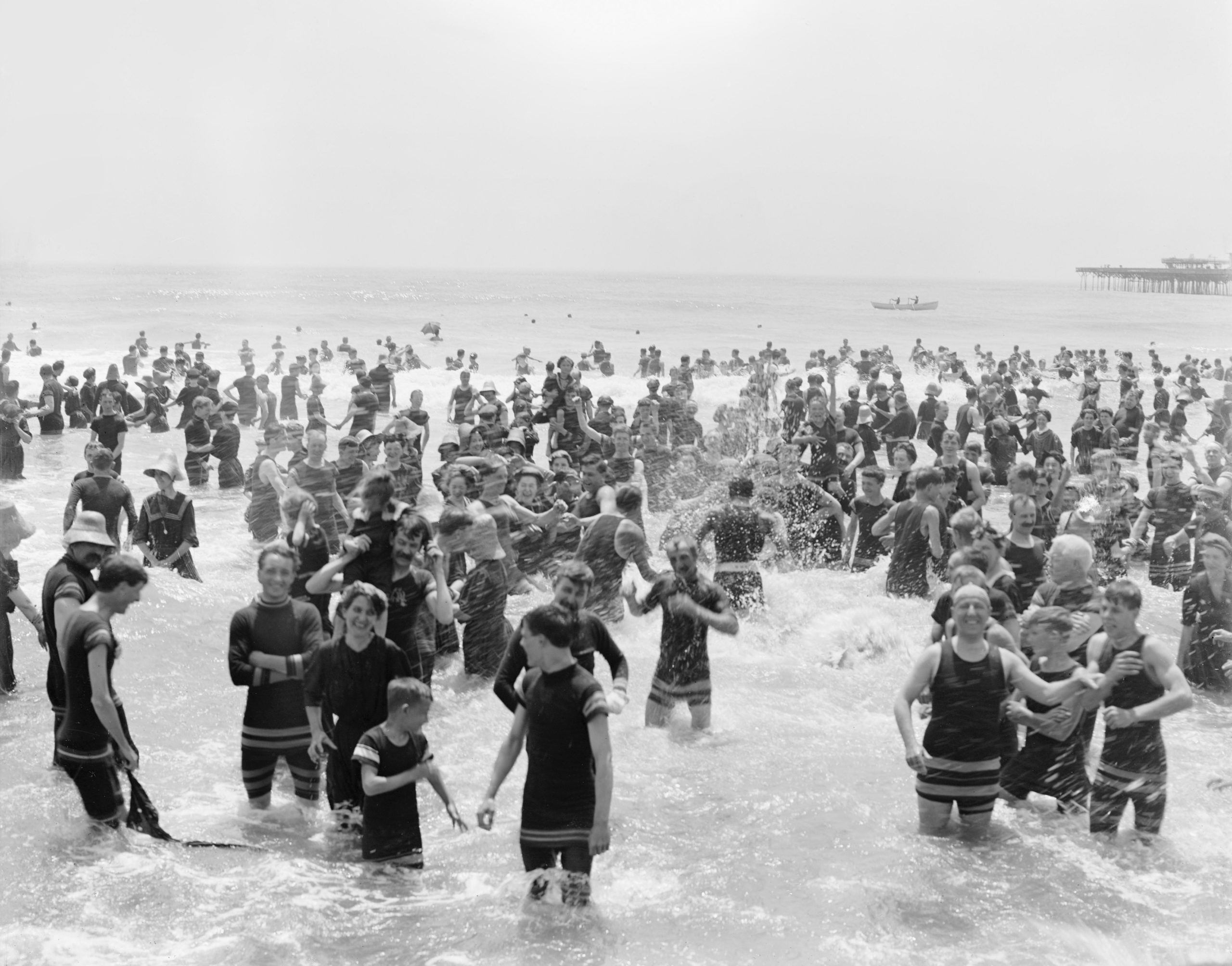 a crowd of people play in the water at the beach