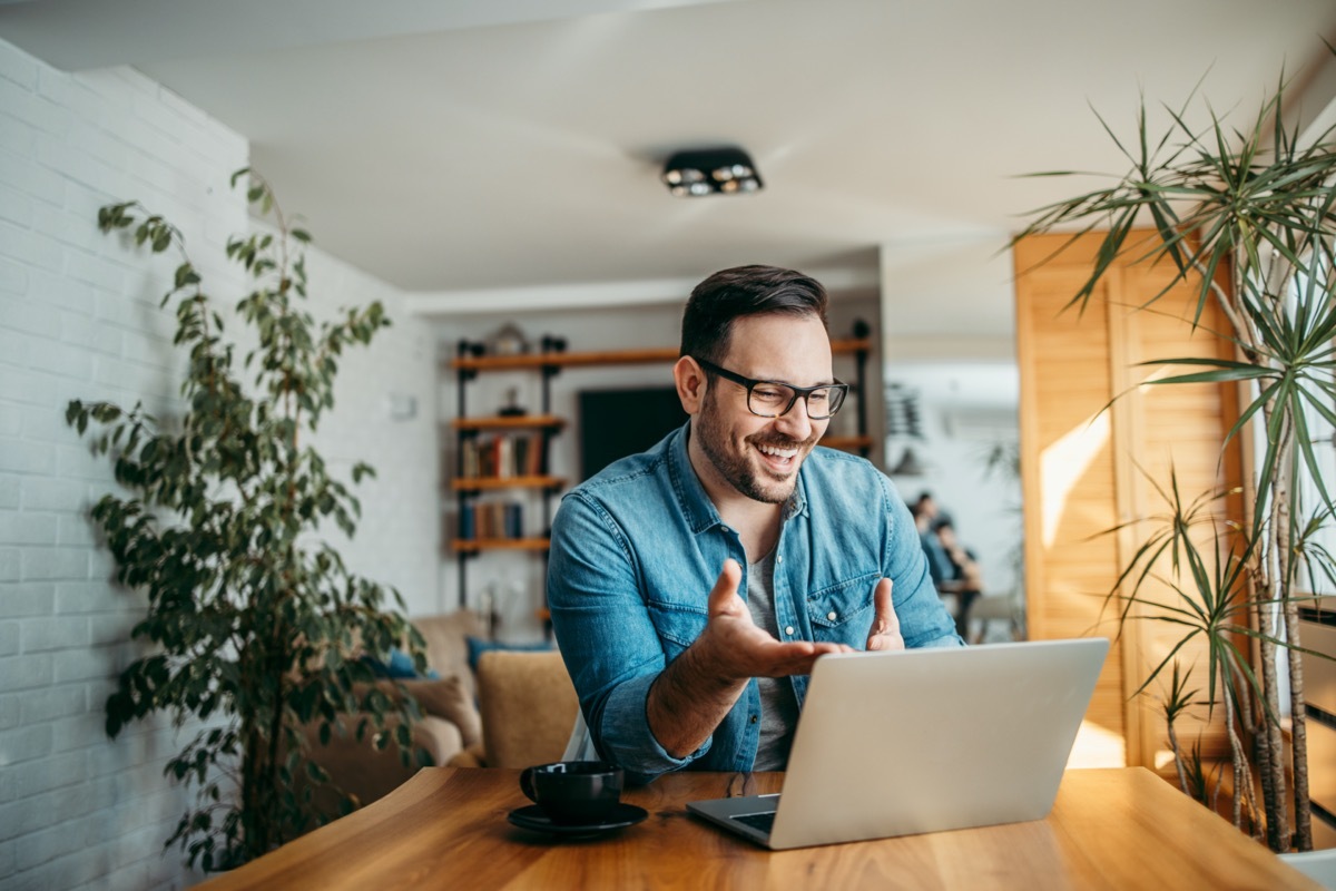 cheerful man having video call on laptop computer