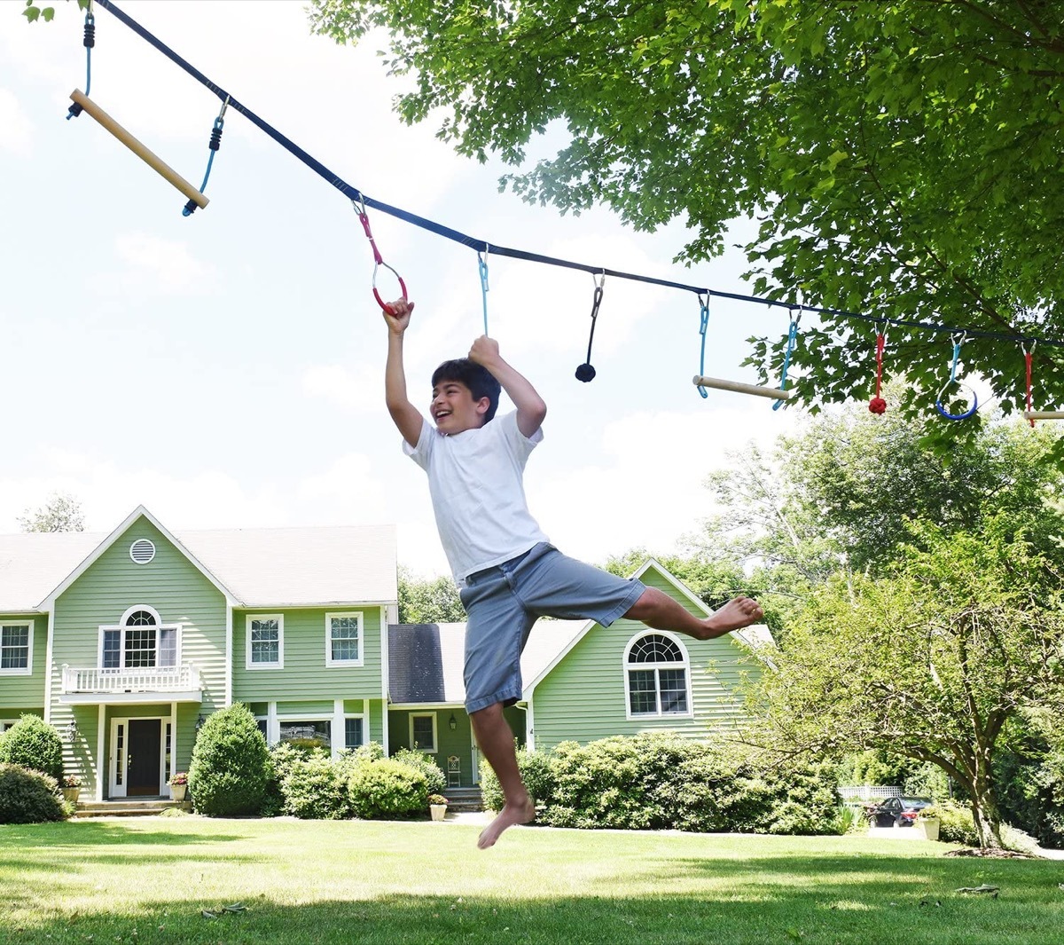 Kid swinging on monkey bars in yard