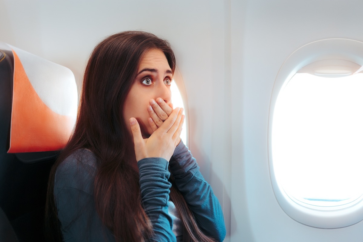 woman with motion sickness on airplane