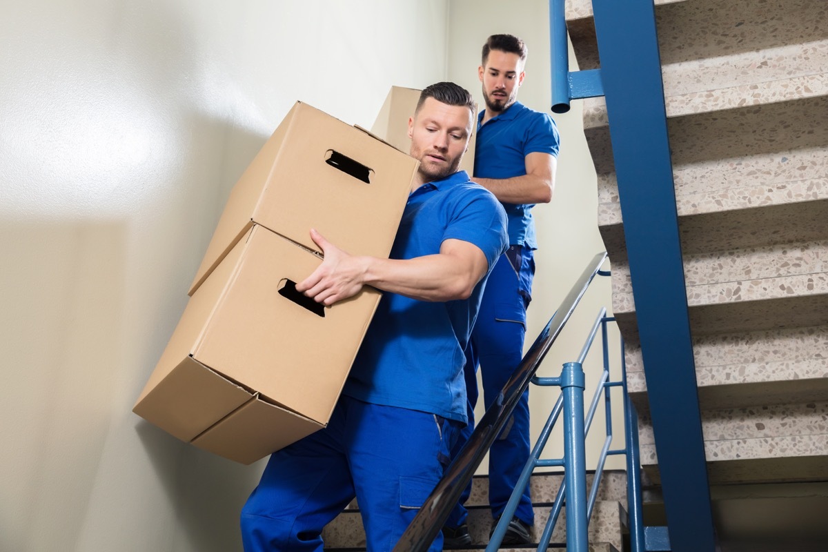 Movers carrying boxes down the stairs