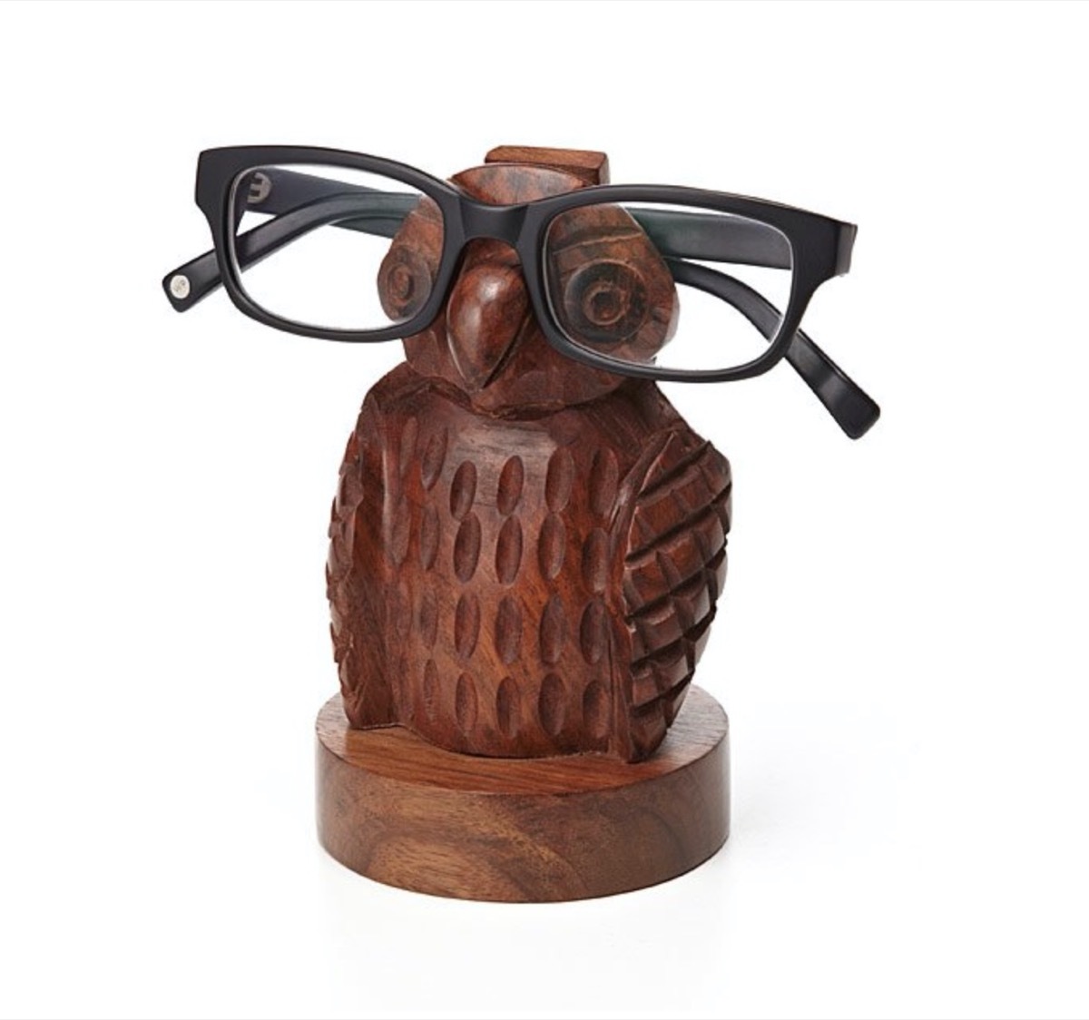 small wooden owel with black human eyeglasses on it