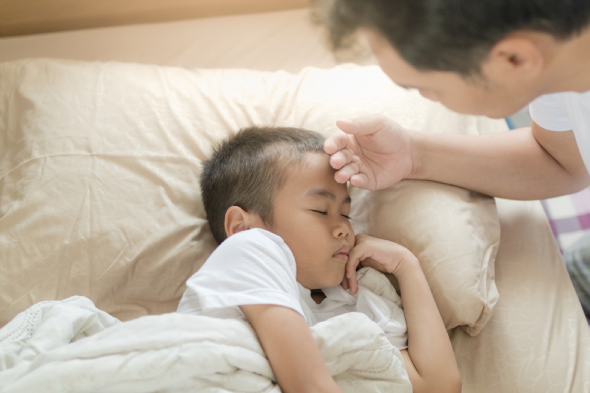 father feeling son's forehead, parenting is harder