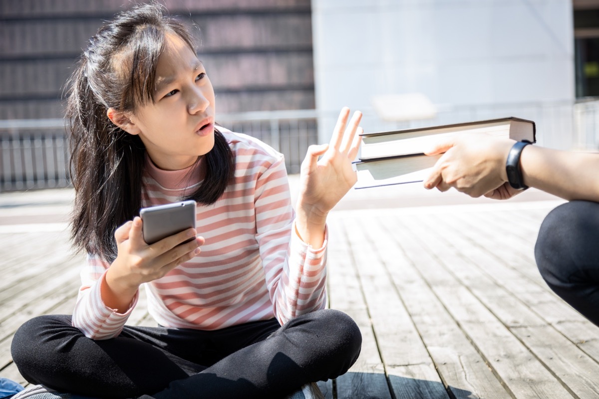 Young Asian Woman Refusing Books