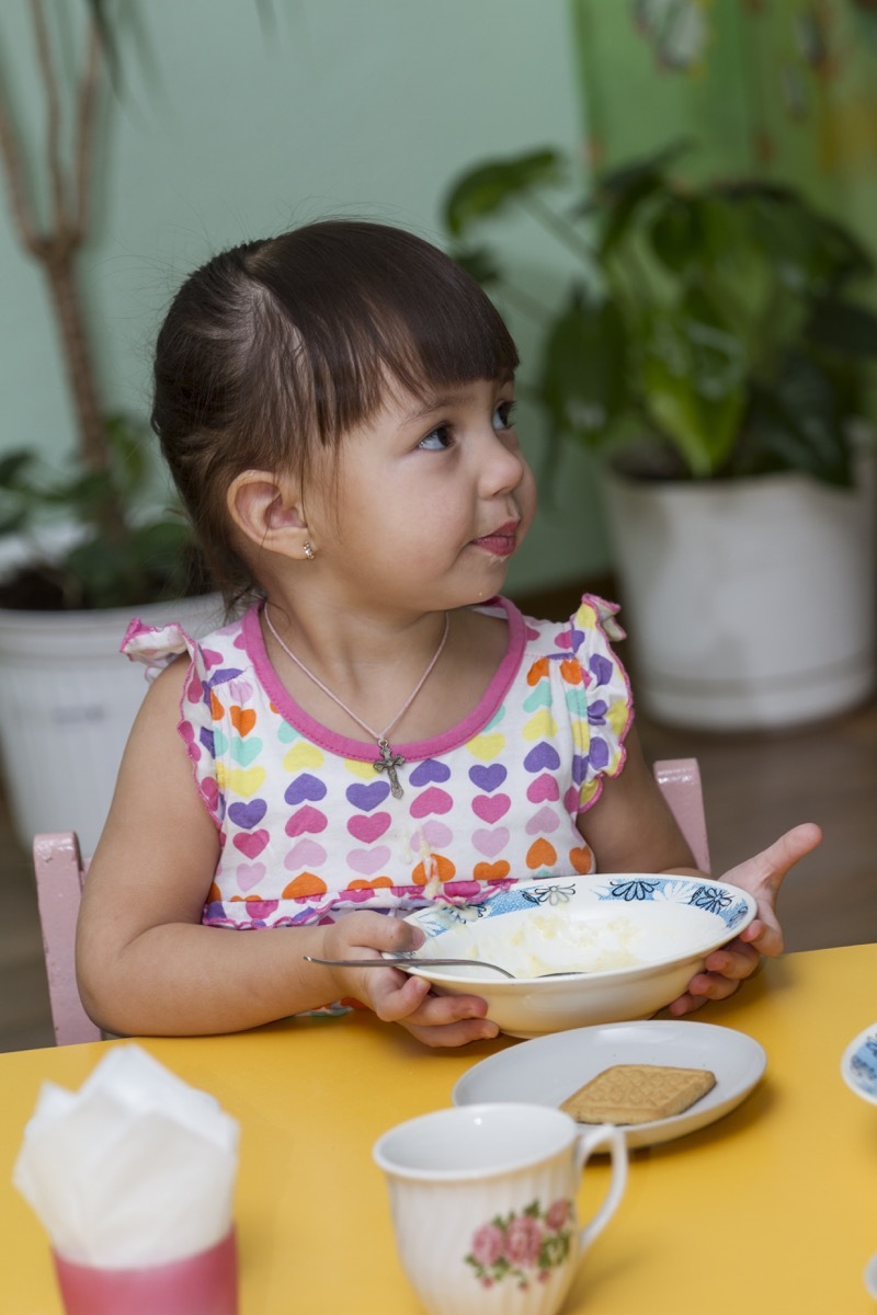 Little girl done eating at the table