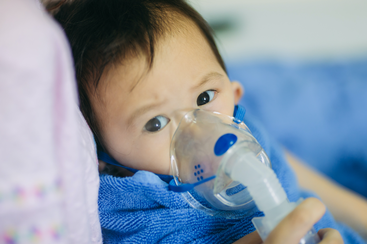 young asian child with respirator