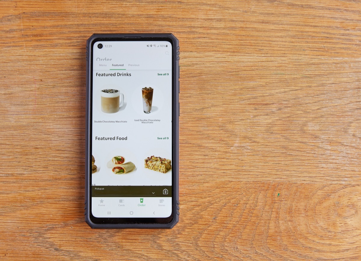 ILFRACOMBE DEVON UK - 26TH JANUARY 2021; Android 'Starbucks' menu phone app on wooden table ordering food in the time of covid