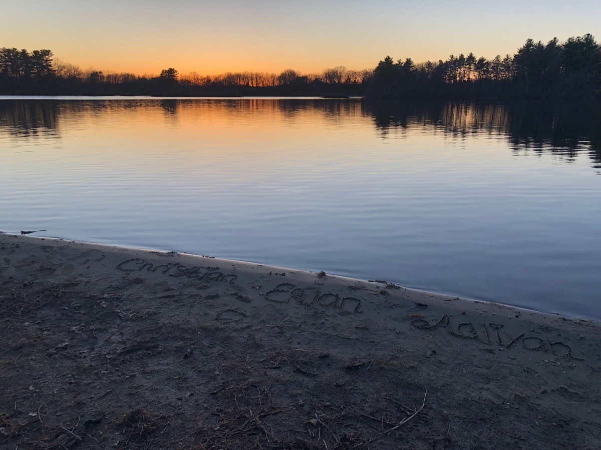 View from the shore of Lake as sun sets, state fact about massachusettes