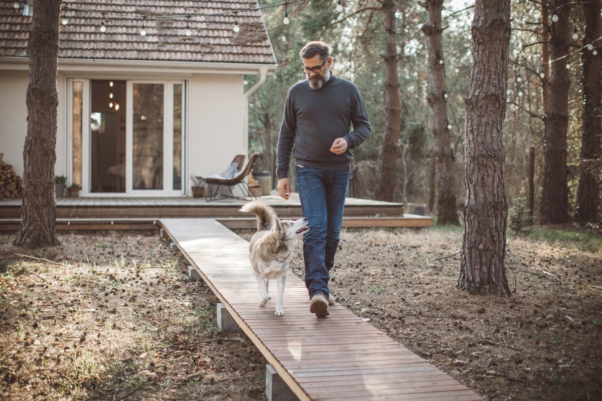 Mature men at home with pet dog during pandemic isolation.