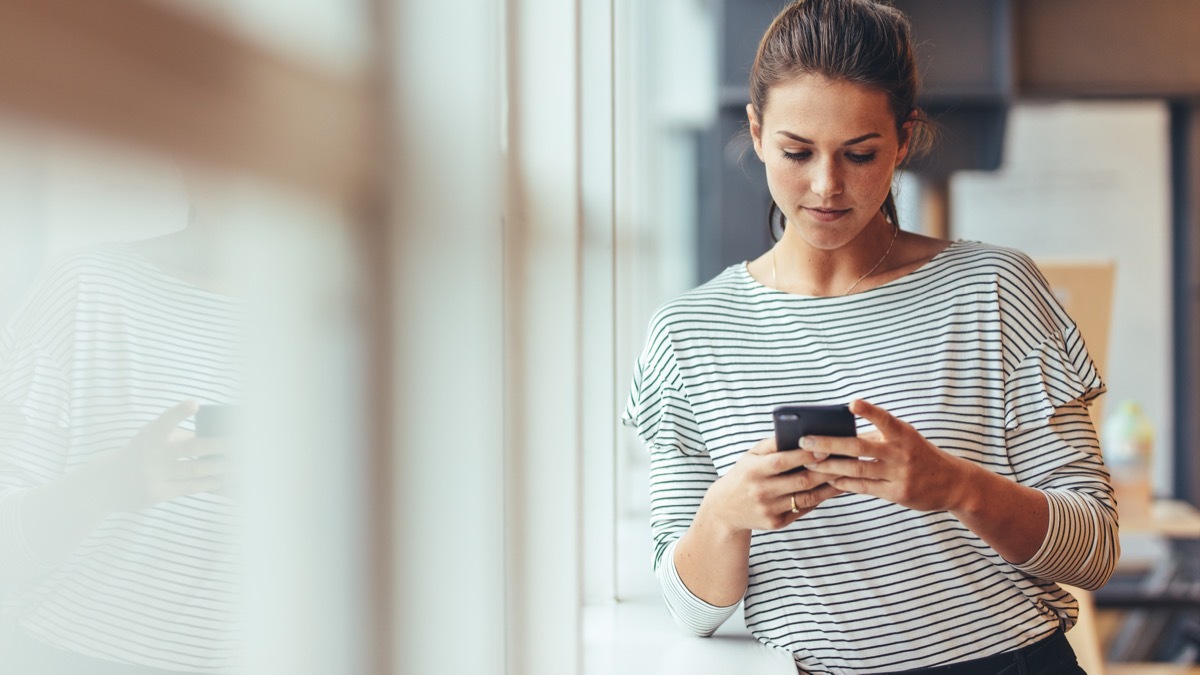 woman at work looking at her phone