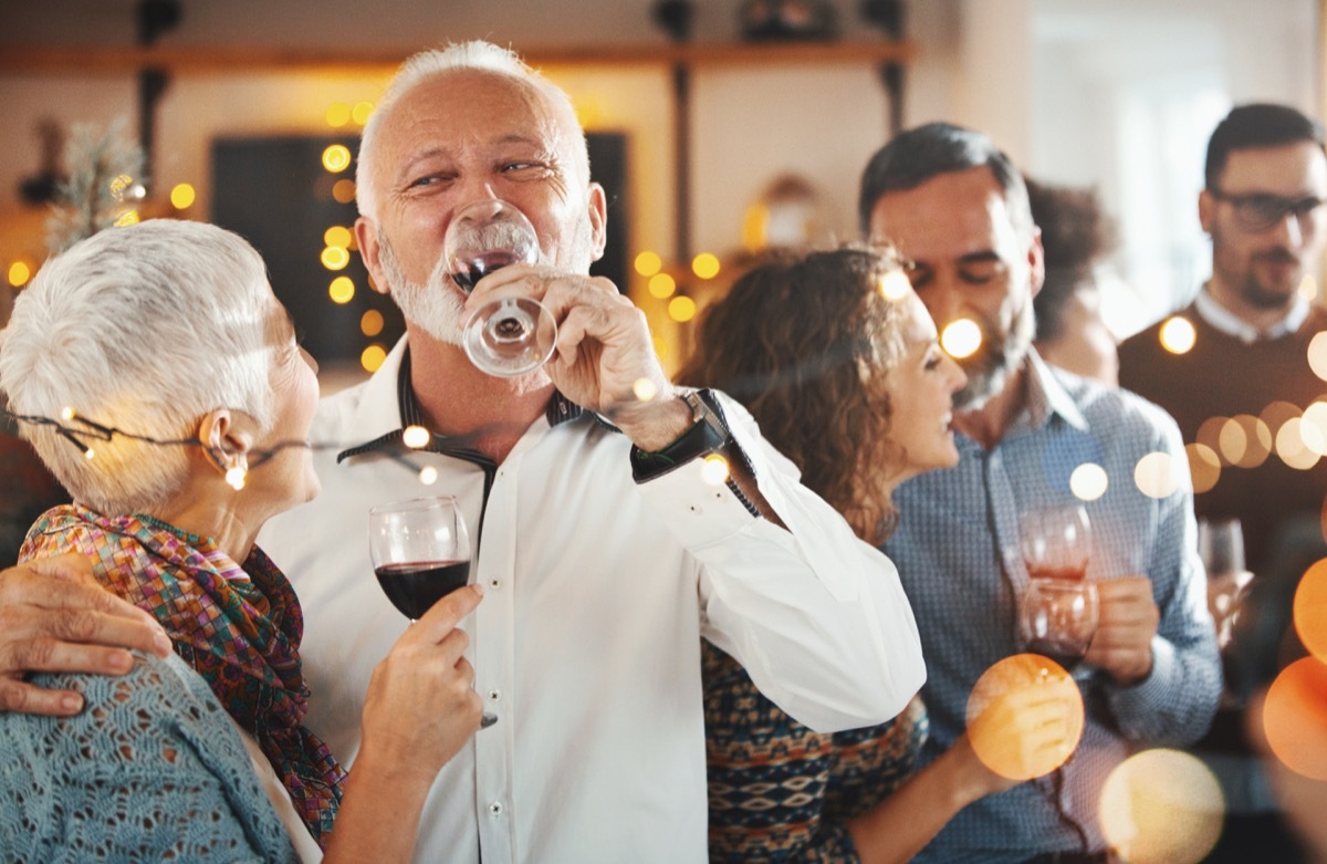 a group of older people talking at a holiday party together