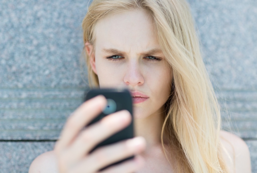 woman on phone looking surprised