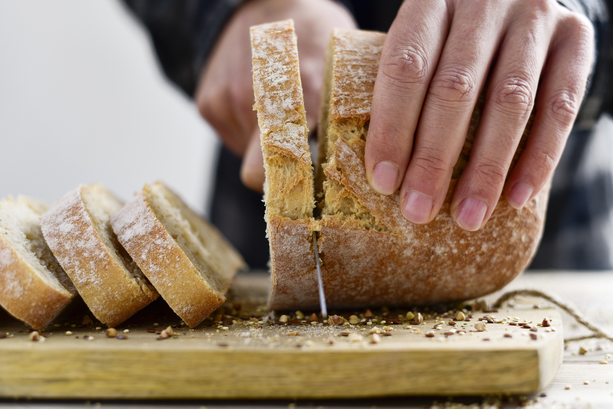 A loaf of bread being sliced.