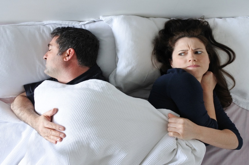 Man in couple is hogging all the blanket in bed