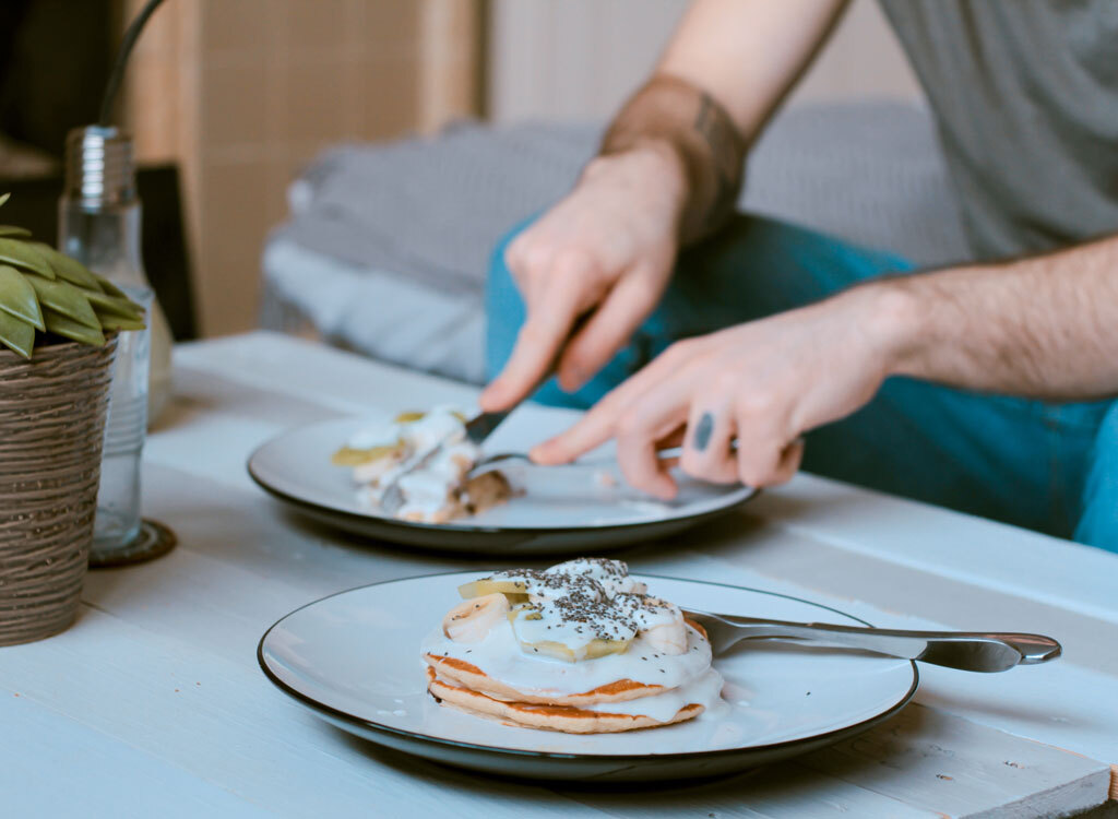 Man eating breakfast at coffee table