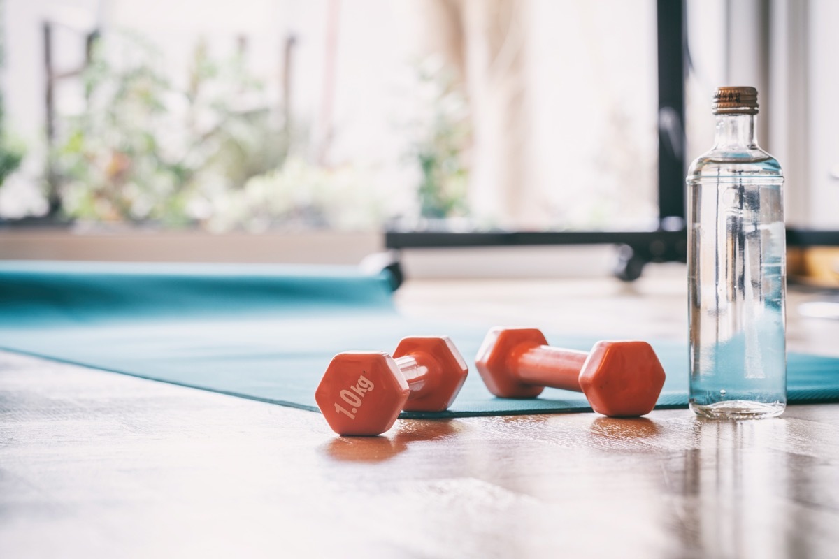 orange dumbbells on wood floor