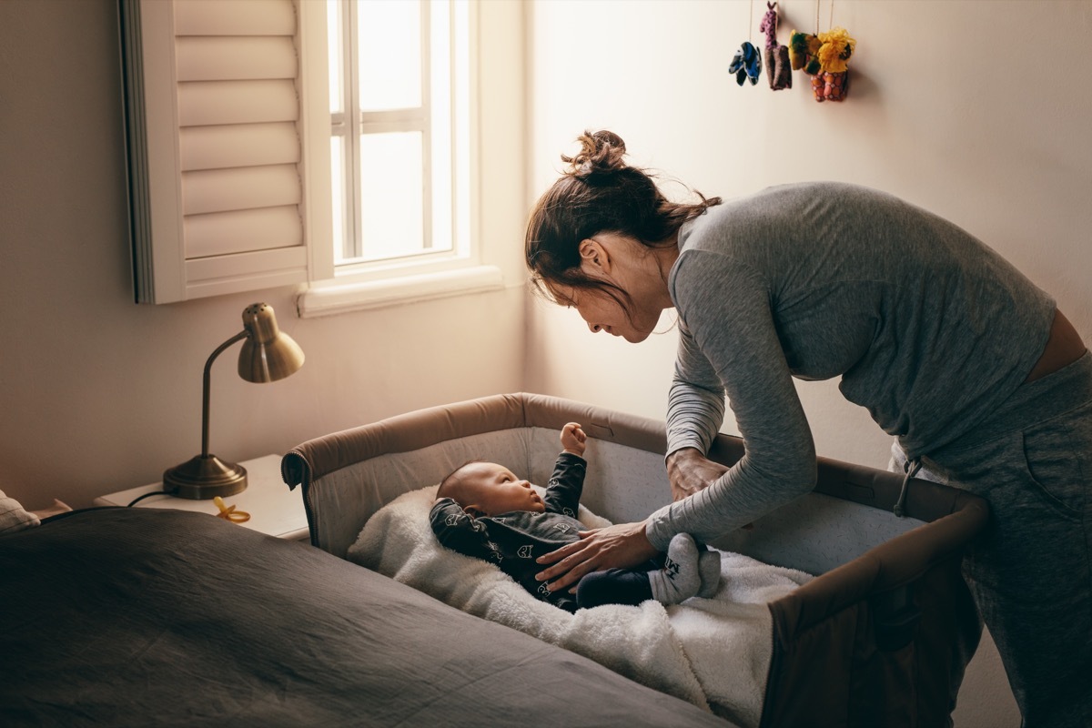 young mother putting her baby to sleep