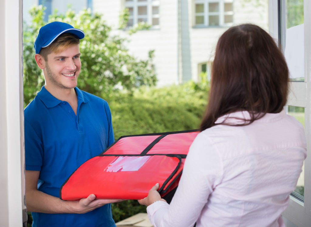 man delivering a pizza to a woman