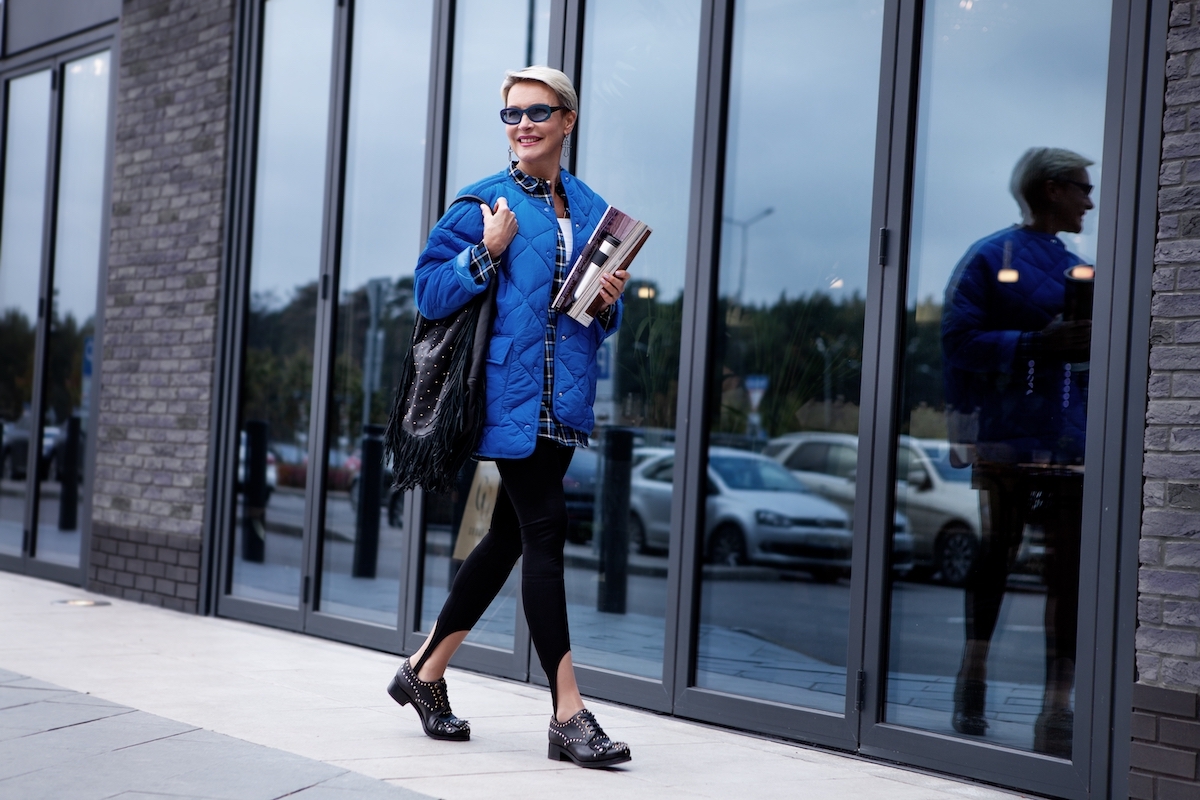 Woman with short blonde hair, blue coat and leggings