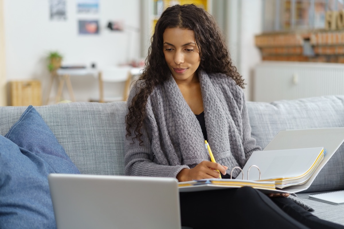 Woman learning online on a sofa.