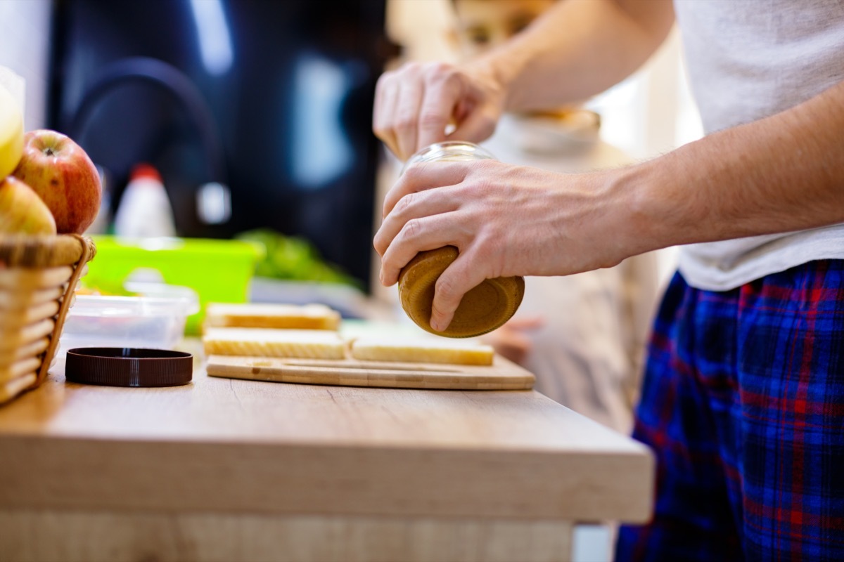 Close-up of unrecognizable father making peanut butter sandwiches for his 6 year old son