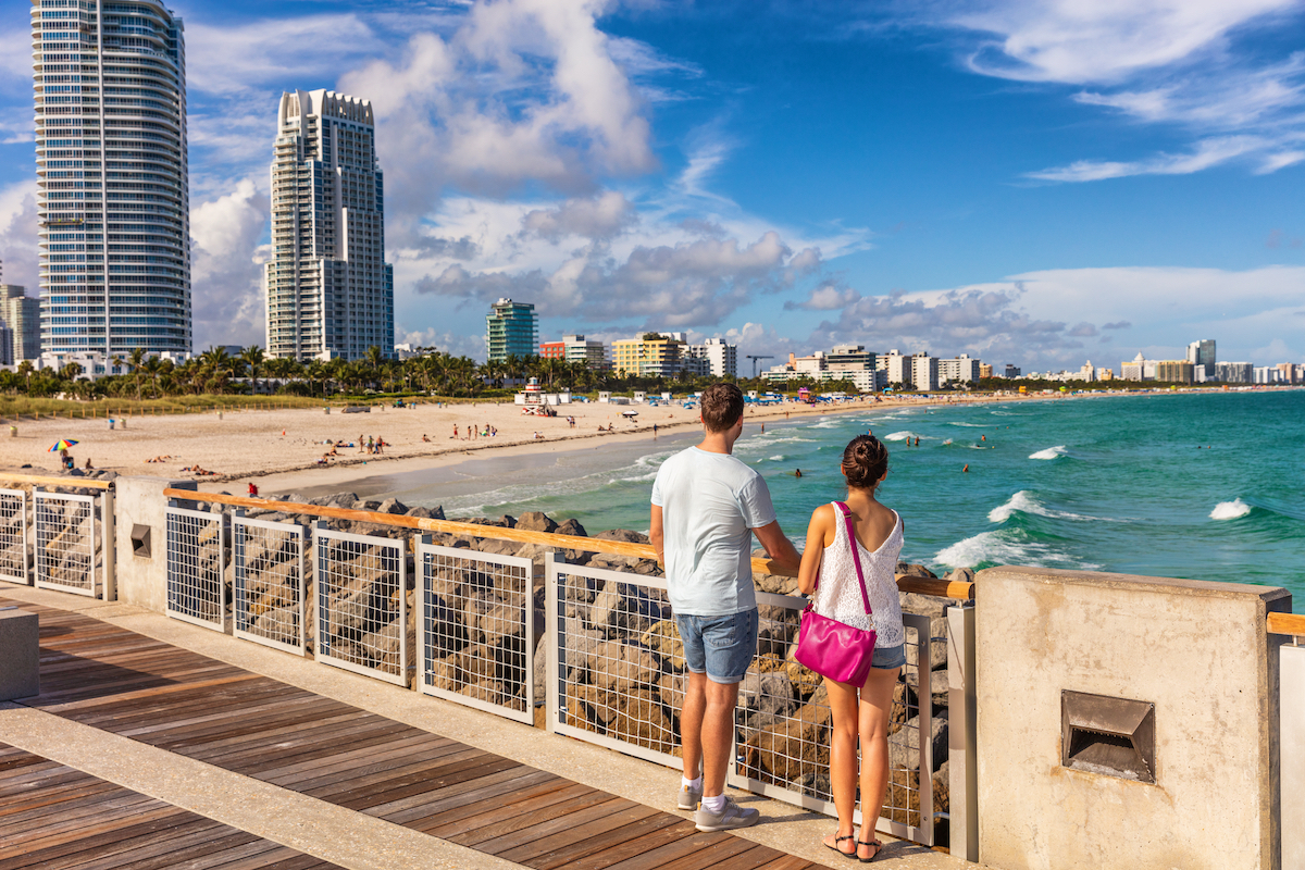 Miami beach tourists couple walking in South Beach, Miami, Florida. USA travel.