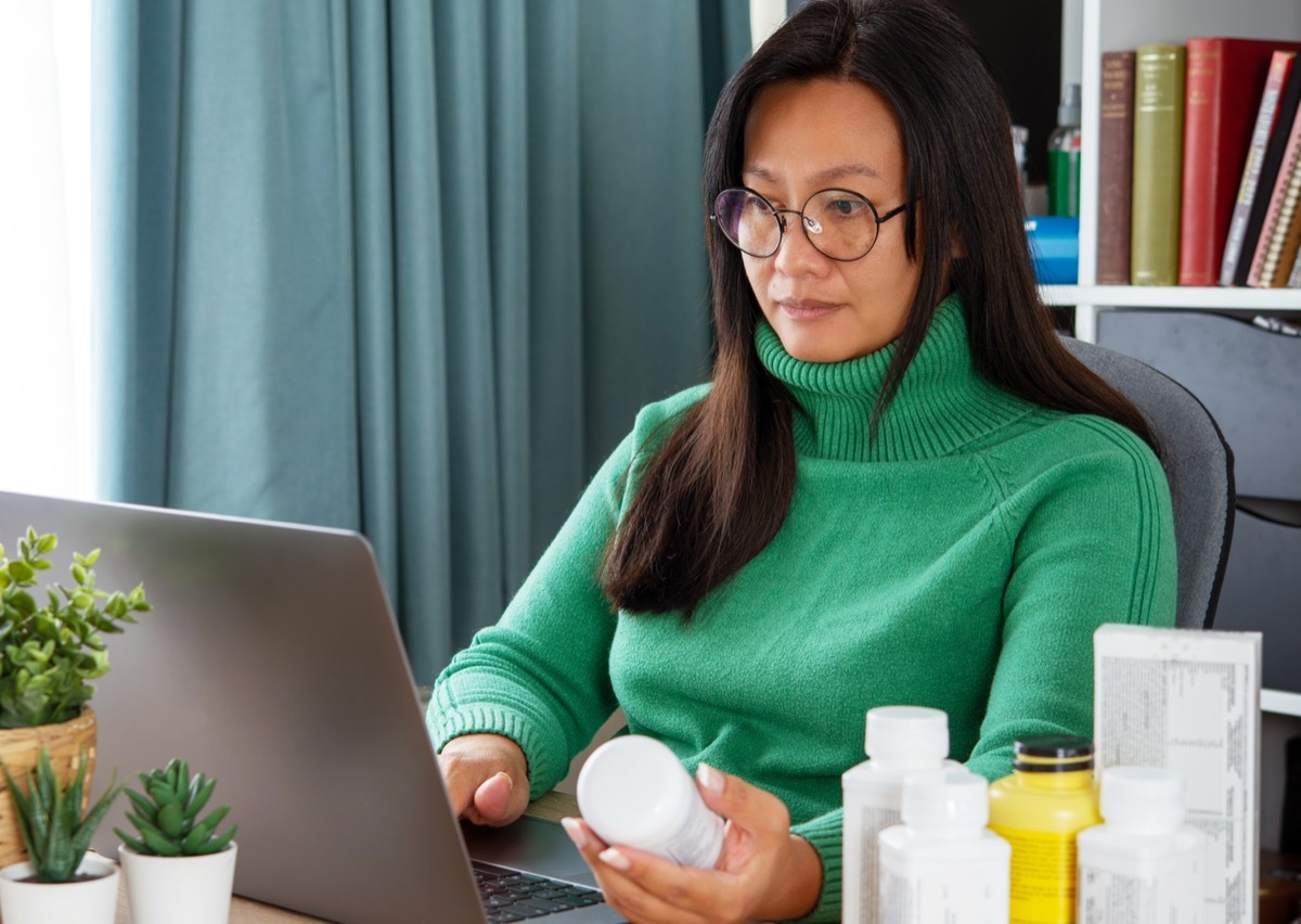 woman looking at supplement bottle