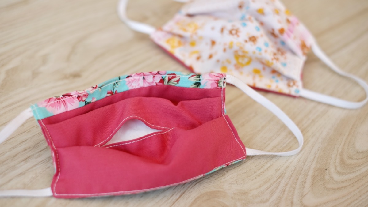 two cloth masks on wooden table with filter pockets