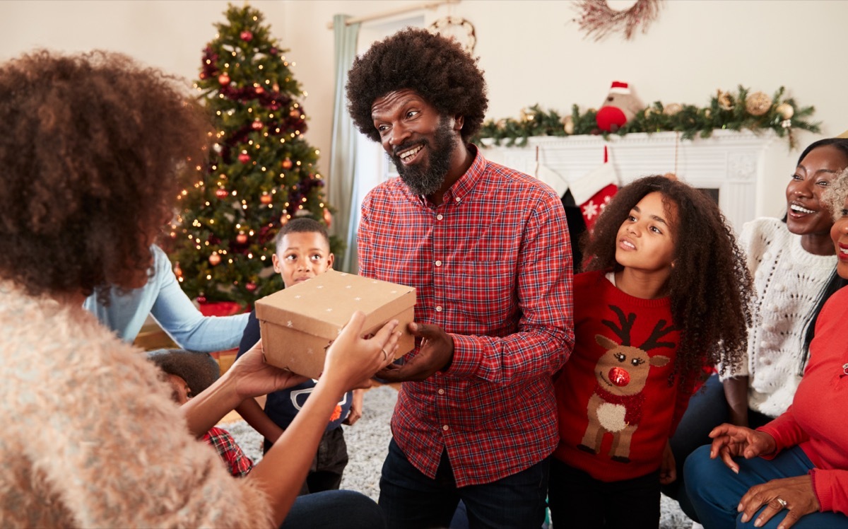 A family showing up at a Christmas celebration with gifts