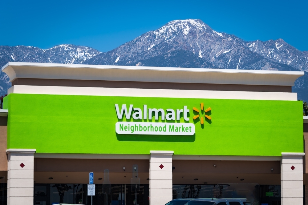 A Walmart Neighborhood Market storefront with snow capped mountains in the background