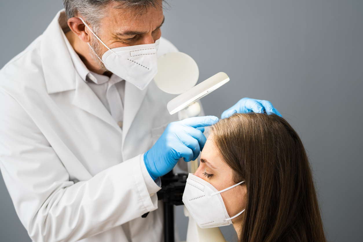 Doctor examining woman's hair.