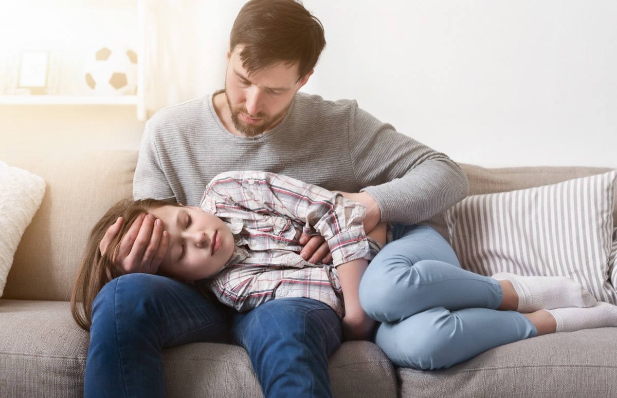 Father taking care of ill little girl. Daughter feeling bad at home