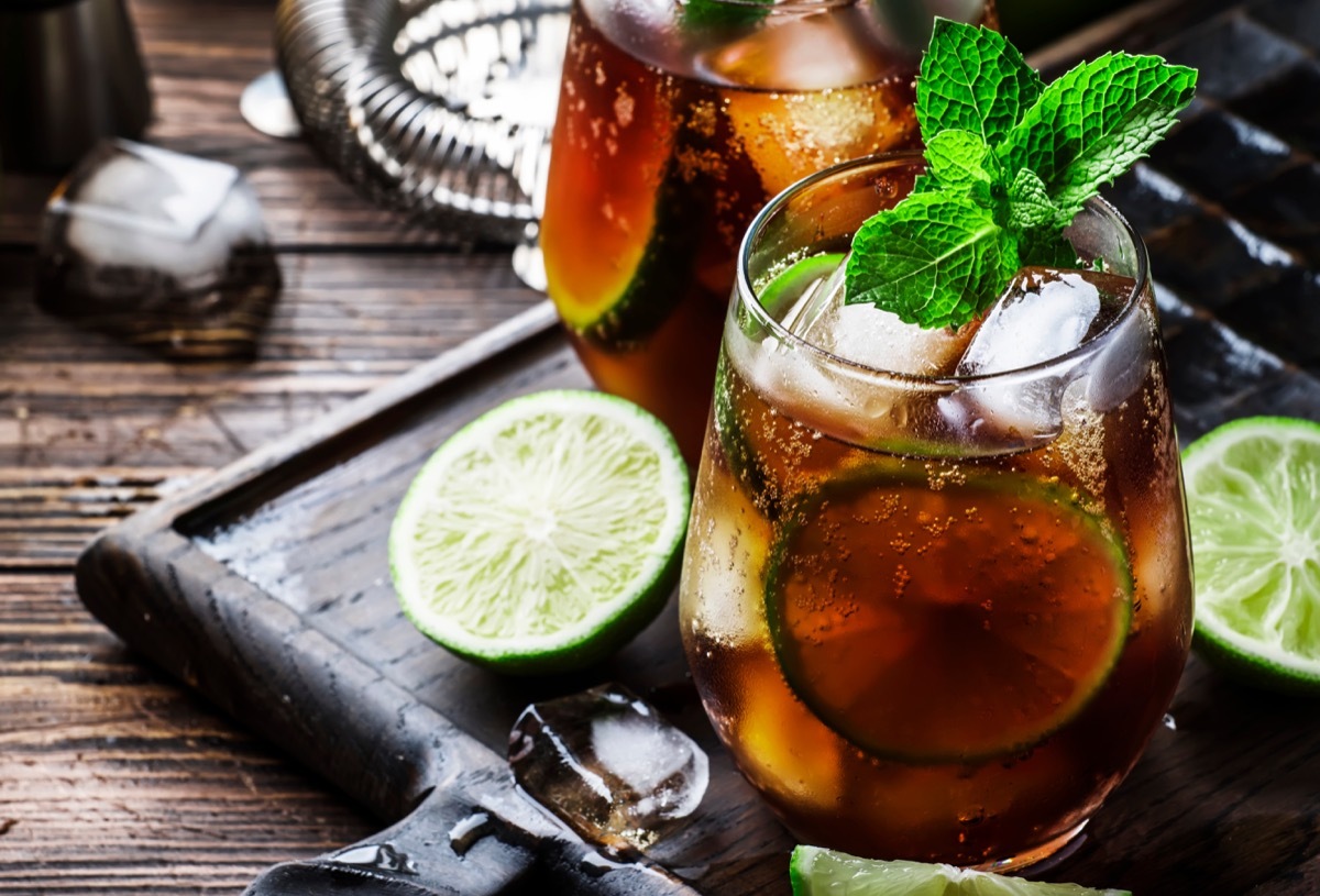 rum and cola, alcoholic beverage with lime, glass on a table