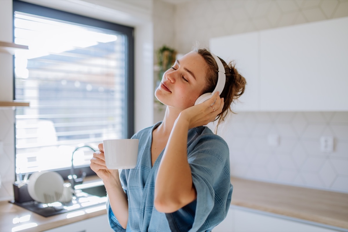 young woman listening to music in the kitchen