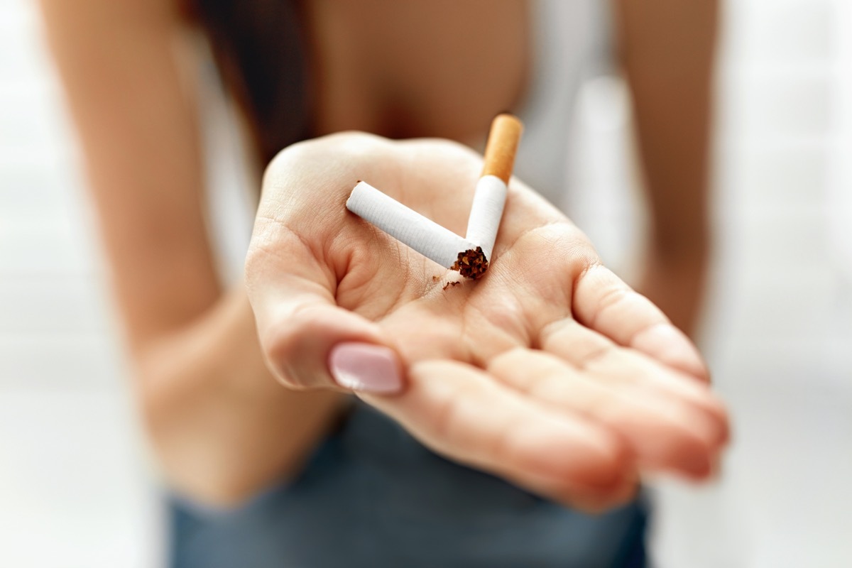 Woman holding broken cigarette