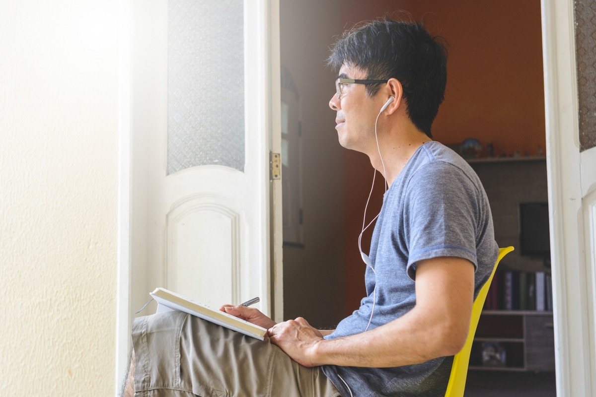 man meditating and writing gratitude journal