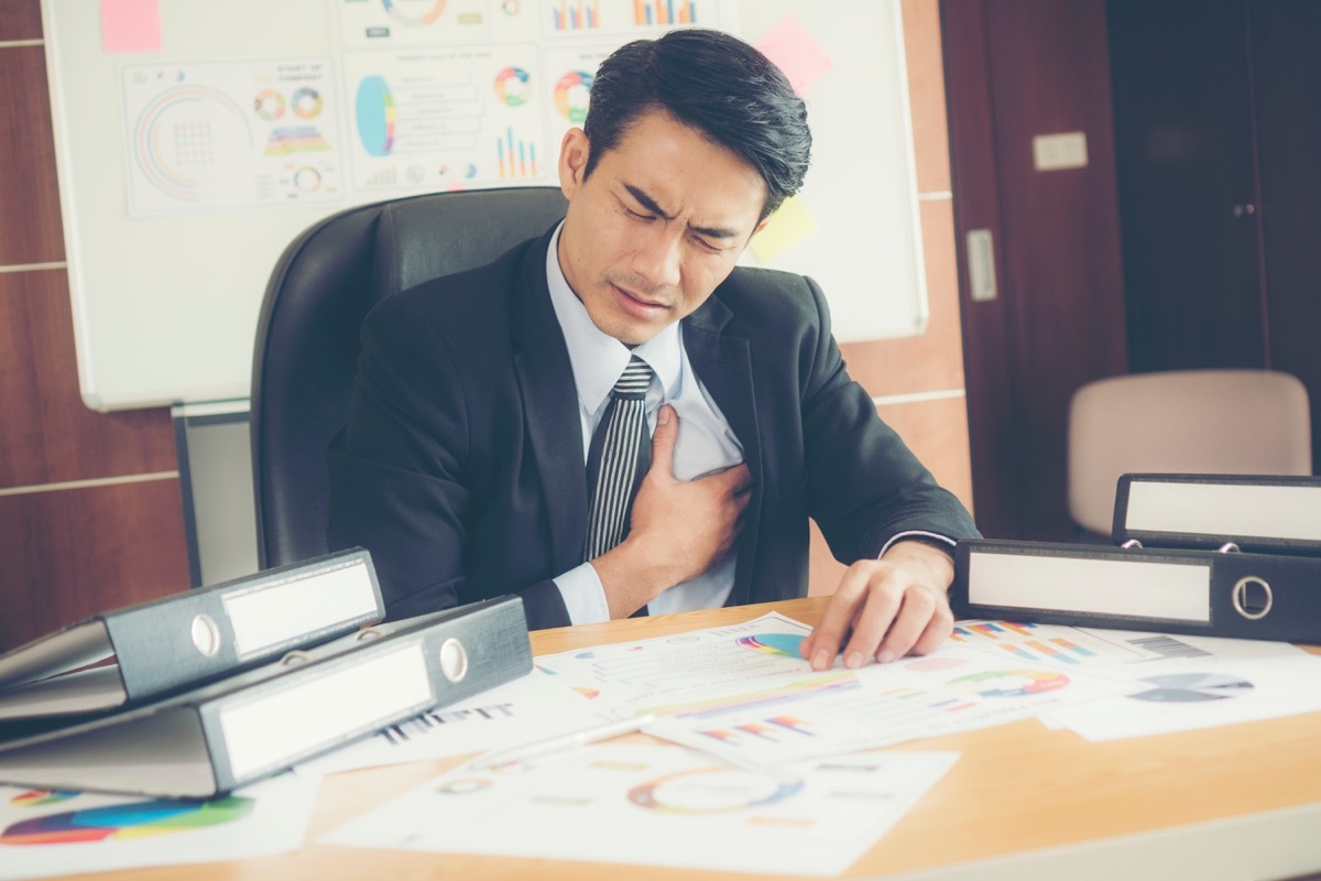 Business man experiencing heart pain at his desk