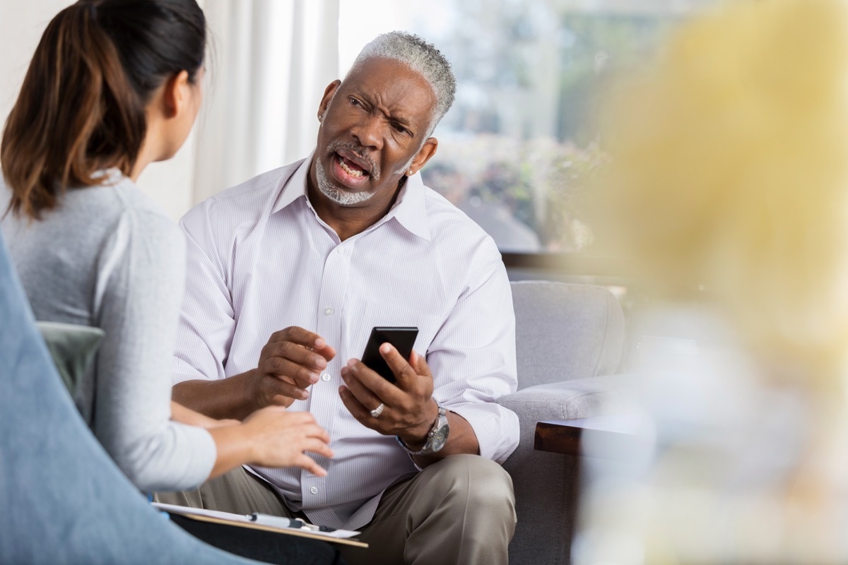 nervous man asking a female therapist for something while holding his phone