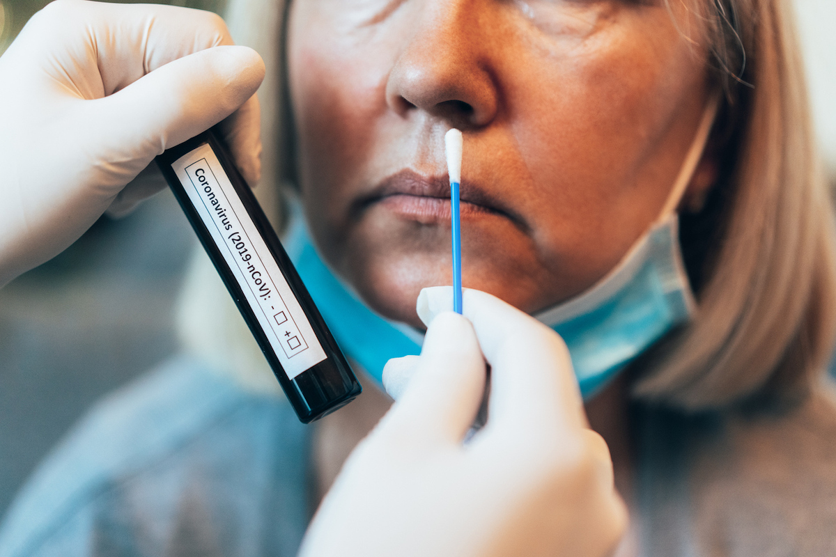 Doctor's hands in protection gloves holds Testing Kit for the coronavirus test