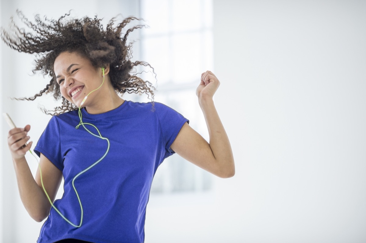 Young woman dancing to music.