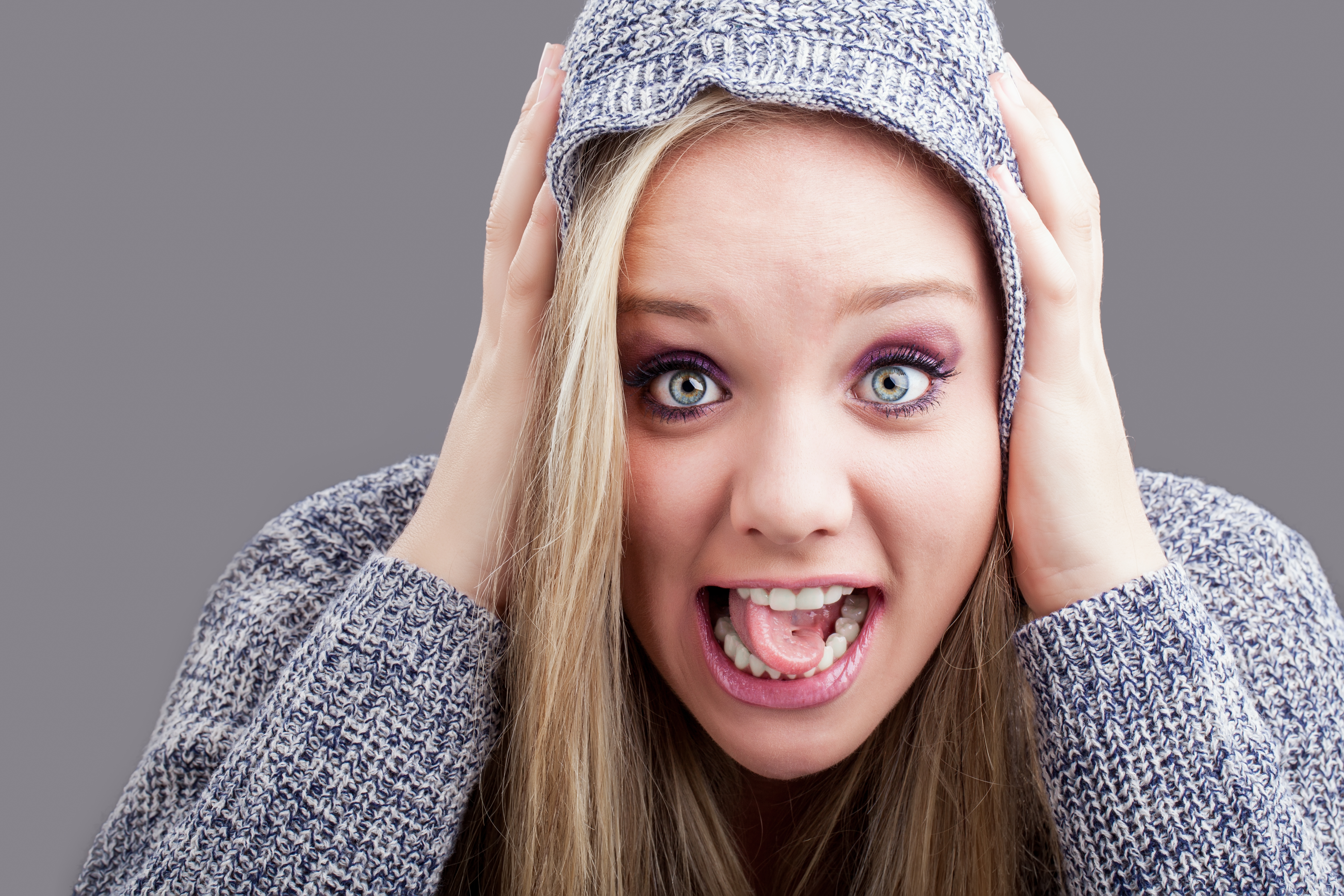 girl with hands on her head and tongue twisted