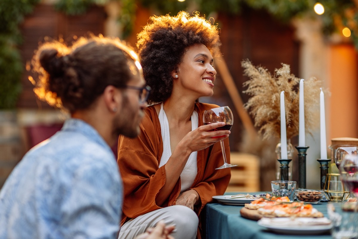 Group of friends socializing at the backyard and drinking wine