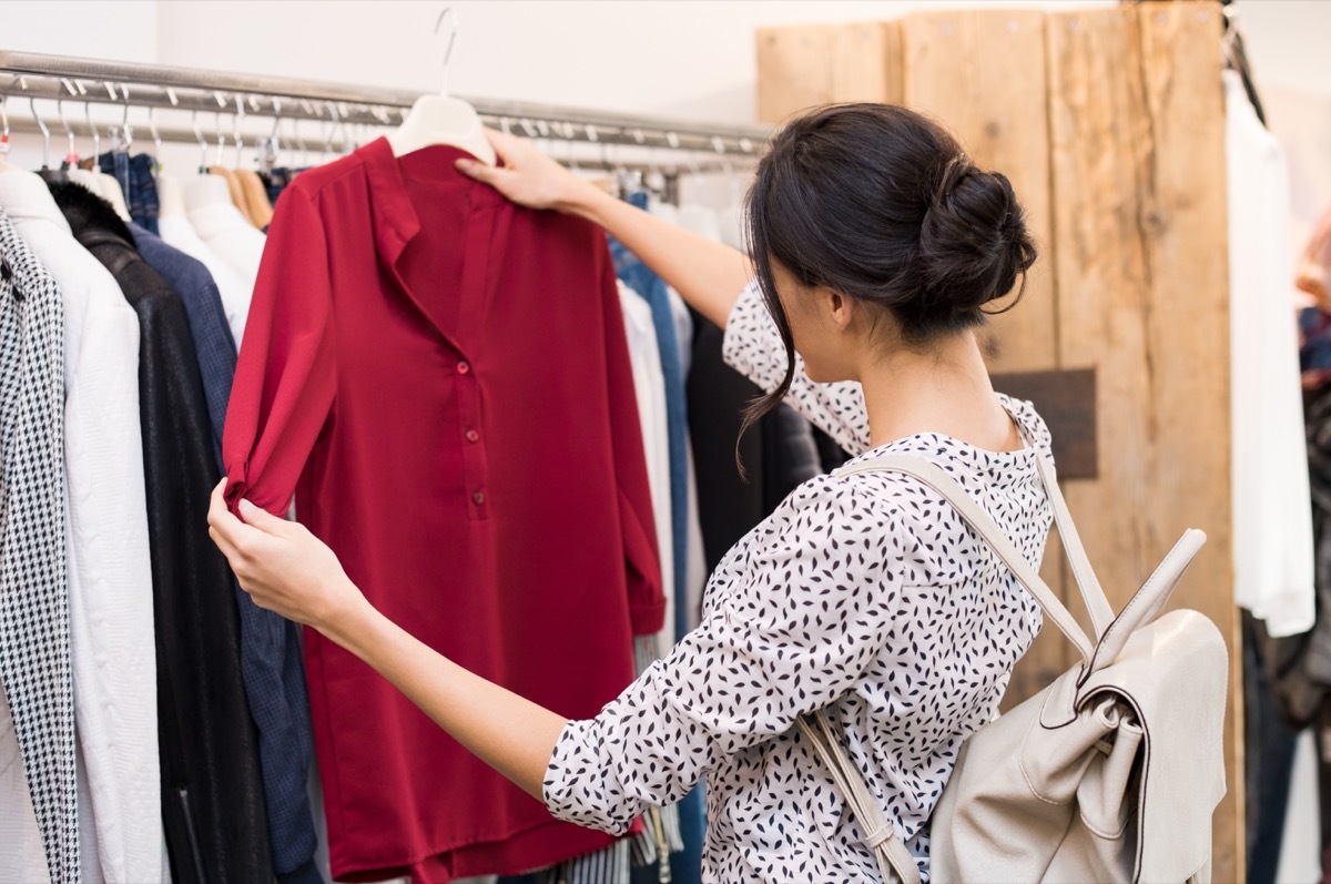 woman checking out a red top in a clothing store